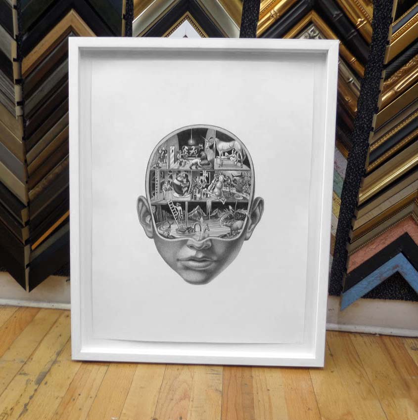 A black-and-white surrealist head drawing in a white box frame